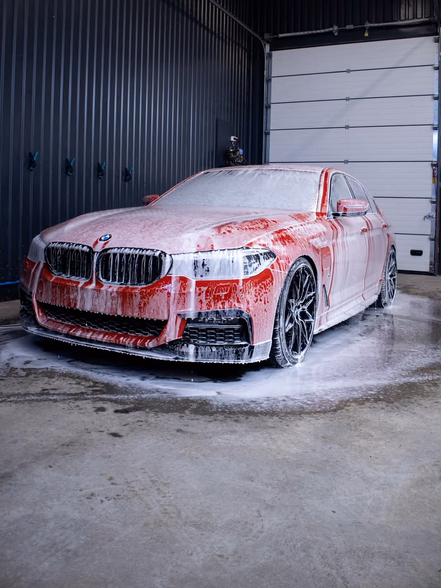 Punainen BMW pesuvaahdon peitossa KM-Detailingin hallissa