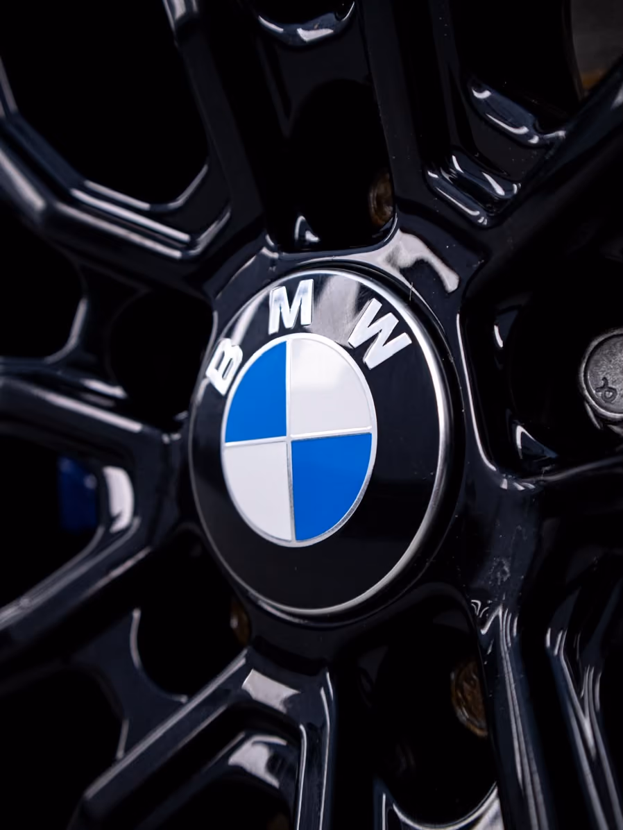 Kiiltävä musta BMW-vanne ja keskiömerkki lähikuvassa